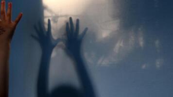 Blur shadows of child hands on wall. Game with light and shadow. Dark spooky silhouettes of hands for Halloween photo