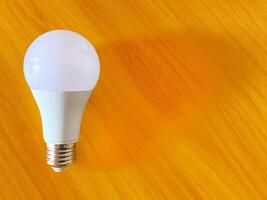 Energy efficient light bulb rests on a vibrant textured ready to illuminate ideas. photo
