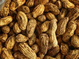 Earthy textured peanuts in their shells create a rustic and natural food background image. photo
