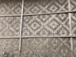 Woven bamboo wall creates a textured pattern with natural tones and rustic charm. photo