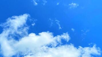 Fluffy white clouds drift lazily across a vibrant blue sky creating a peaceful atmosphere. photo