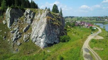 A scenic landscape with a fascinating rock formation next to a gently flowing river. Clip video