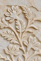 Intricate jaal pattern featuring floral motifs carved into a textured stone surface, showcasing craftsmanship and artistic detail in a harmonious design photo