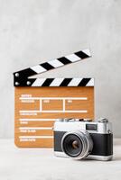 Vintage camera positioned in front of a wooden film clapperboard, showcasing the essence of filmmaking and photography, capturing creativity and artistic expression in a studio setting photo