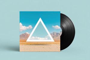 Vinyl record mock up featuring a geometric triangle design against a vibrant blue sky with clouds and desert landscape, ideal for music or art projects photo