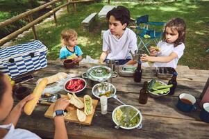 Family Enjoying a Picnic Outdoors with Fresh and Colorful Food in a Scenic Park photo