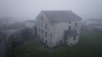Dense fog envelops an abandoned house in the countryside, creating an atmosphere of mystery and eerie solitude video