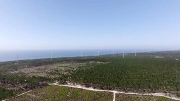 Aerial view over a windfarm near the sea, showing the vastness of the land and the scale of the renewable energy project video