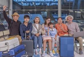 Three generation family with friends waiting for flying in the airport for airline travel,destinations,gathering and taking photo together for preserving good memories