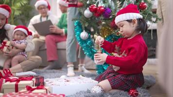Little child with a joyful moment for a large family celebrating together at home during the Christmas season video