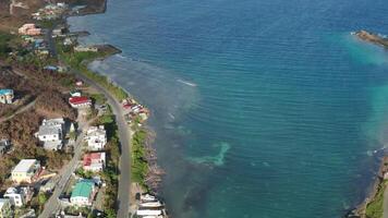 Tilting up from Tortola, BVI coastline as car drives on coastal road video
