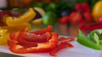 Close up shot of chef's hands using a knife cutting a fresh bell pepper on wooden board. Cooker preparing Cutting peppers on the cutting board. Chop the green pepper into small pieces with a knife video