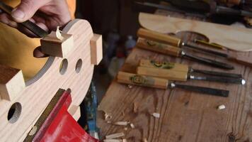 Luthier working with a chisel in a new violin or viola video