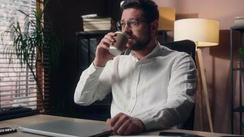 Caucasian ceo business leader guy developer male sip coffee drink beverage cup in office employer executive open laptop businessman agent begin workday job man manager starting working occupation tech video