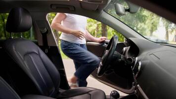 Happy satisfied glad Caucasian elderly female mature senior woman car auto driver open door sit inside automobile vehicle fastens seat belt buckle up adjusting rearview mirror preparing drive machine video