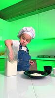 Young chef baking in a colorful kitchen. A child in a chef hat measures flour from a blender in a vibrant kitchen setting, showcasing their baking skills. video