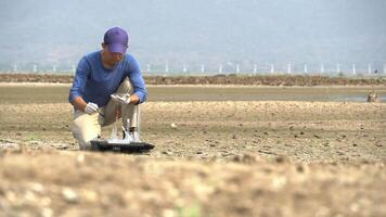 asian scientist analyze an water and soil to find solutions of soil deterioration problems. video