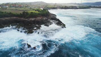 Waves crashing on the rocks, drone view with blue ocean on Lembongan island, panoramic shot video