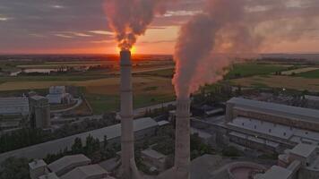 setting sun behind of smoke out of concrete factory, aerial view. what a view video
