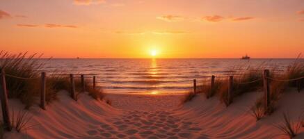 Panoramic shot of a peaceful beach at dawn or dusk, with gentle waves rolling towards the shore and a brilliant sun on the horizon photo