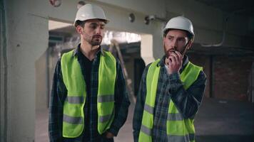 Caucasian men electricians builders guys architects males try speak walkie talkie broken device fail problem handymen foremen show new radio set tech mechanics communicate in construction manufacture video