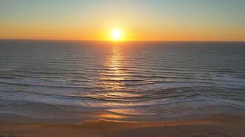 Top-down drone view of golden sunset reflecting on ocean surf and textured waves video