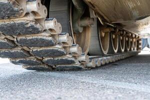 Tank track close-up view from the bottom on asphalt photo
