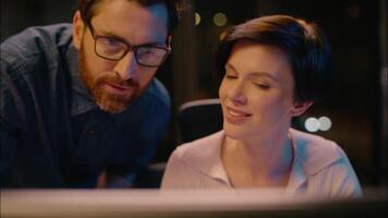Caucasian business man boss come check project work woman smiling co-workers girl guy businesswoman businessman browsing computer at dark night office professional mentor teach help intern consulting video