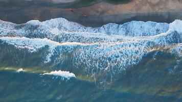 Overhead Of An Ocean With Long Waves Crashing Onto The Sand At Sunset video