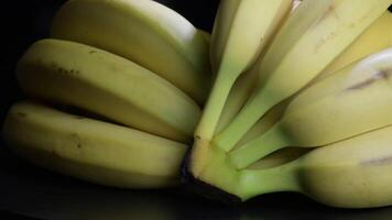 Bunches of bananas gyrating on black background video