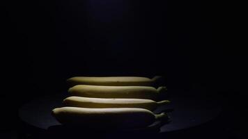 Bananas in a row gyrating with black background video