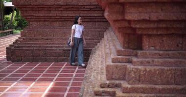 Solo female tourist enjoys strolling around to appreciate the serene surroundings and the cultural richness of the place. Traveling and vacation concept video