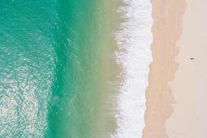 top down drone shot of turquoise ocean and a solitary red accent on a paradise beach, aerial drone view photo