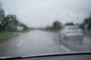 Rain drop on the car glass window while driving on the road. photo