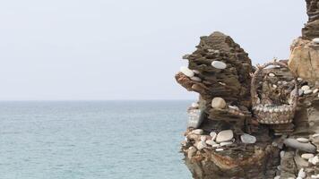 Stones with requests and objects on rocks by the sea video