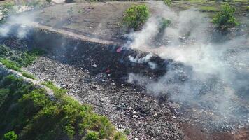 Burning illegal dump with smoke. Pollution by plastic on landfill, aerial view. video