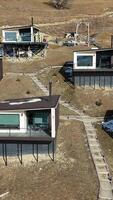 Modern hillside cabins with large glass windows, offering panoramic views of the valley, under construction in a remote countryside setting, blending nature with contemporary design video