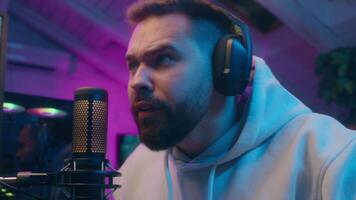 Joyful Caucasian male guy gamer streamer playing computer tech e-sport at home man winning shout winner rejoice addict influencer celebrate game victory champion receive golden cup blogger stream neon video