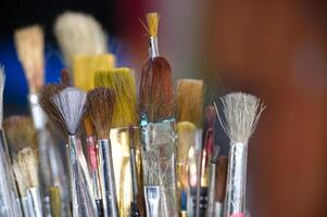 Close-Up of Assorted Paintbrushes in an Artistic Studio Setting photo