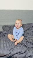 A truly adorable baby happily plays on a soft and cozy bed, showcasing a variety of cheerful expressions that are ideal for familycentered and childrens marketing efforts video
