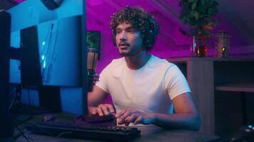 American Latino Arabian Muslim man play computer online game player guy cyber sport networks male pc gaming blogger streamer at home night gamer in headphones talk microphone influence vlogger video
