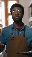 African American professional coffee factory worker man guy looking at camera talking speaking at warehouse packaging shelf clipboard inspection process quality caffeine industry male beans production video