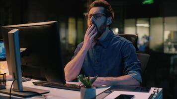 Business man tired sleepy guy businessman yawning overtime working computer in night dark office overwork male workaholic weary exhausted employee yawn low energy late time sleeping insomnia fatigue video