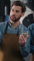 Coffee experts workers compare cups beans using laptop aroma analysis African American Caucasian men small business owners flavor digital review tasting multiethnic teamwork precision roasting factory video