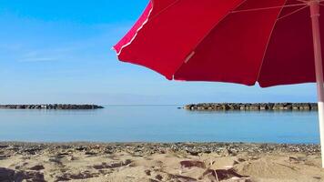 Summer Umbrella on the Beach. Part of a Red beach Umbrella Against the Backdrop of a Beautiful Blue Sea and Sun. Tourism and Summer Concept. video