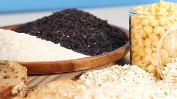 A vibrant arrangement of grains, breads, and pasta in bright lighting, showcasing diverse textures and colors video
