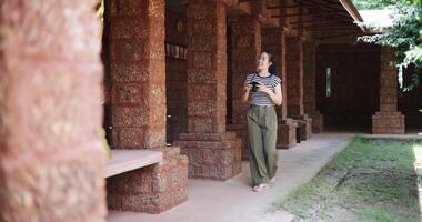 Handheld shot, Happy young woman in casual clothes walking exploring and enjoying taking photos at an ancient site, Enjoy holiday travel. video