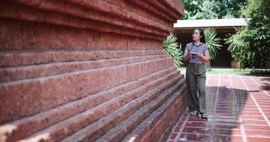 Handheld shot, Happy young woman walking exploring and enjoying taking photos at an ancient site, Enjoy holiday travel. video