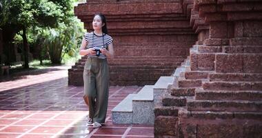 Happy young woman in casual clothes walking exploring and enjoying taking photos at an ancient site, Enjoy holiday travel. video