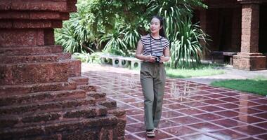Happy woman in casual clothes walking exploring and enjoying taking photos at an ancient site, Enjoy holiday travel. video